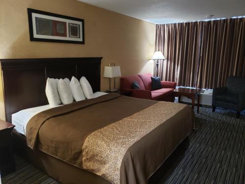 a hotel room with a bed and a chair at Florence Express Inn in Florence
