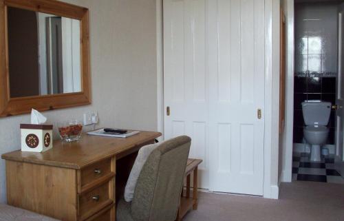 a room with a desk and a sink and a mirror at Lairg Highland Hotel in Lairg