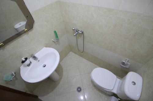 a bathroom with a white toilet and a sink at Mona`s apartments 1 in Sarandë