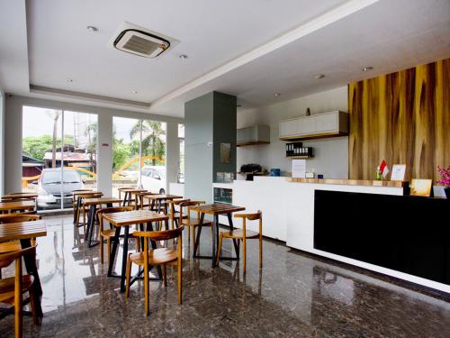 a restaurant with tables and a bar with a tv at Super OYO Flagship 3486 The Regia Tambun in Bekasi
