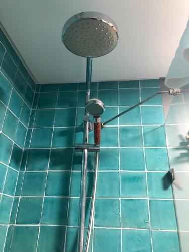 a shower in a bathroom with blue tiles at Casa da Praça Guest House in Sesimbra
