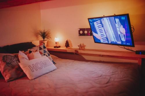 a bedroom with a bed with a flat screen tv at Departamento SUR in Ushuaia