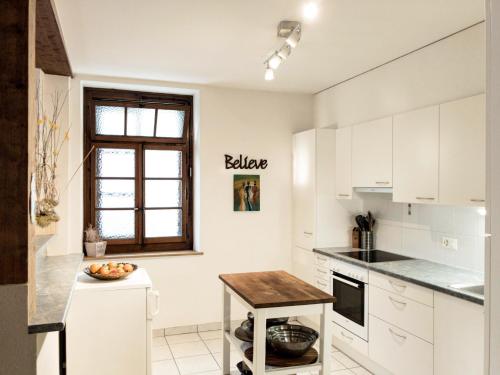 a kitchen with white cabinets and a table at Cozy Getaway in the Heart of the Swiss Riviera in Villeneuve
