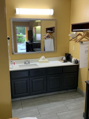 a bathroom with a sink and a mirror at Baymont by Wyndham Selma in Selma