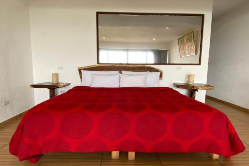 a red bed with a red blanket on top of it at Hotel Santa Rosa in Valle de Bravo