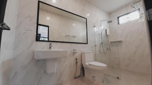 a bathroom with a sink and a toilet and a mirror at Parada Ayutthaya in Pak Kran