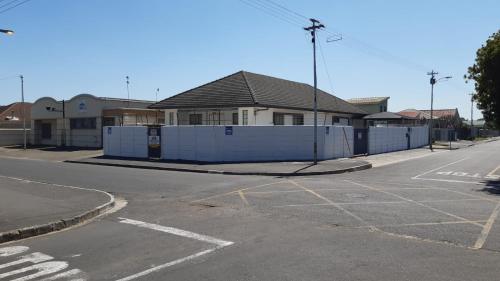una strada vuota con una recinzione bianca di fronte a una casa di MJ ACCOMODATION a Città del Capo