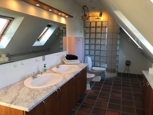 a bathroom with two sinks and a toilet at Dejligt værelse med eget bad og havudsigt in Assens