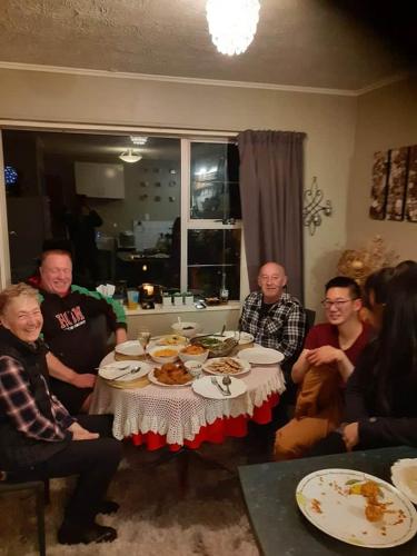 a group of people sitting around a table with food at rooms with a view in Haywards