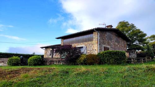 an old stone house with a cat on the roof at Can Castell de Rocabruna in Camprodon