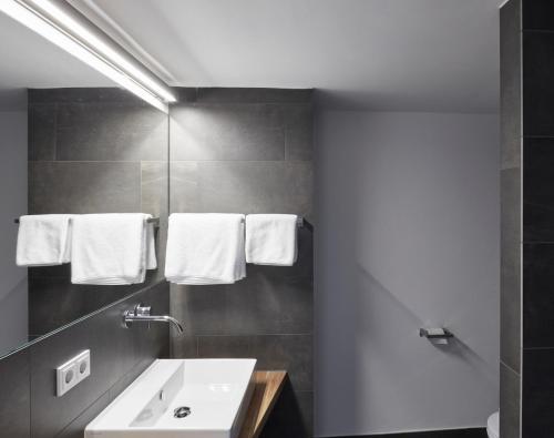 a bathroom with a sink and towels on the wall at Faktorei in Innsbruck