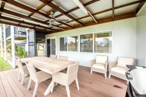 a dining room with a wooden table and chairs at Grasstree Beach Shacks in Grasstree Beach