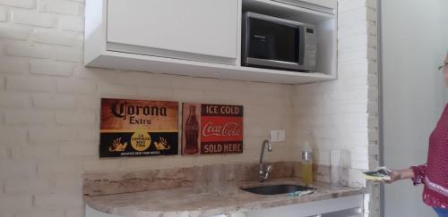 a kitchen counter with a sink and signs on the wall at Flat Angra Portogalo in Angra dos Reis