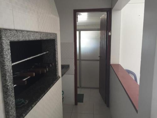 baño con chimenea y puerta a una habitación en Aptos 5 pessoas a 50m do mar 025, en Florianópolis