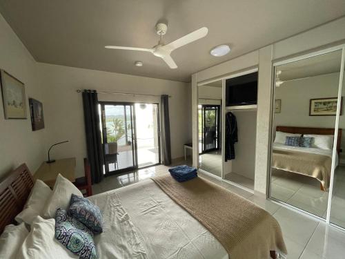 Riva-La-Vista-Cooktown في كوكتاون: غرفة نوم بسرير ومروحة سقف