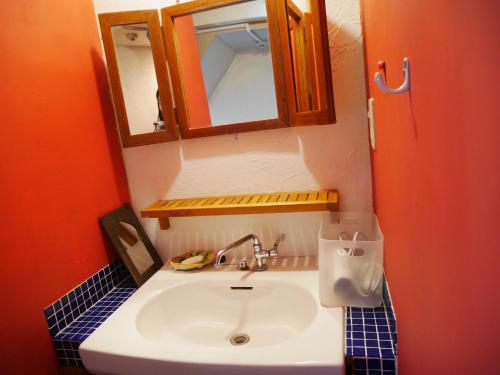 ein Bad mit einem Waschbecken und einem Spiegel in der Unterkunft Guest House mii in Osaka