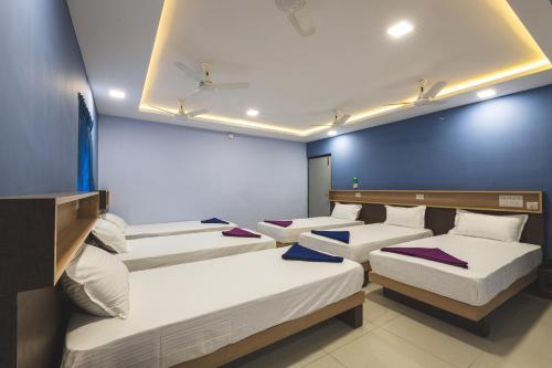 a row of beds in a room with blue walls at SKM REGENCY in Chennai