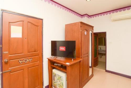a living room with a tv on a wooden stand at Ban Ao Thong in Trang