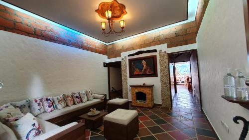sala de estar con sofá y chimenea en El Quijote Apartahotel, en Jericó