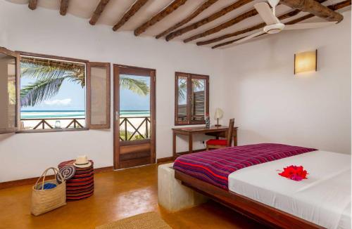 a bedroom with a bed with a view of the ocean at Hekaya Zanzibar in Pingwe