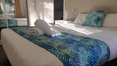 Un dormitorio con una cama con una toalla. en Aqua Villa Holiday Apartments en Coffs Harbour