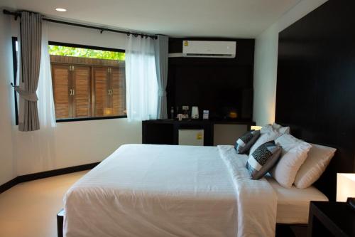 
a bed in a hotel room with a white comforter at Klong Prao Resort - SHA Extra Plus in Ko Chang
