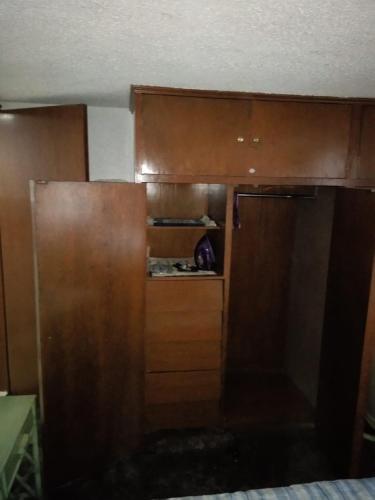 a kitchen with a brown refrigerator and wooden cabinets at Casa de Irma para visitar la ciudad o de negocios in Mexico City