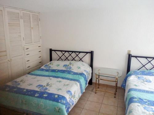 a bedroom with two beds and a chair at Casa de Irma para visitar la ciudad o de negocios in Mexico City
