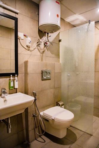 a bathroom with a toilet and a sink and a shower at GoldenKeys Inn in New Delhi
