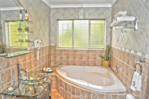 a large bathroom with a tub and a window at Ipe Tombe Guest Lodge in Midrand
