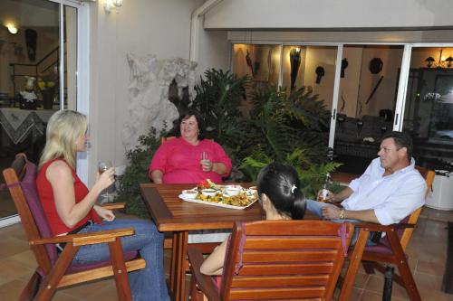 a group of people sitting around a table at Ipe Tombe Guest Lodge - Midrand in Midrand