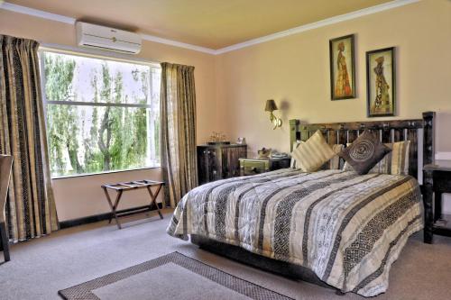 Ipe Tombe Guest Lodge - Midrand tesisinde bir odada yatak veya yataklar