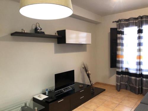 - un salon avec une télévision et un canapé dans l'établissement Velez Apartment, à Vélez de Benaudalla
