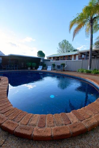 a large swimming pool with a brick wall around it at Ruthven Street Motor Inn in Toowoomba