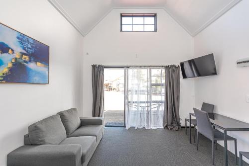 a living room with a couch and a table at Burwood Motel in Whanganui