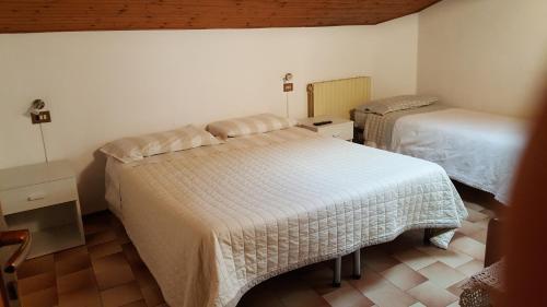 a bedroom with two beds in a room at Foresteria Lombarda da Giovanna in Barzio