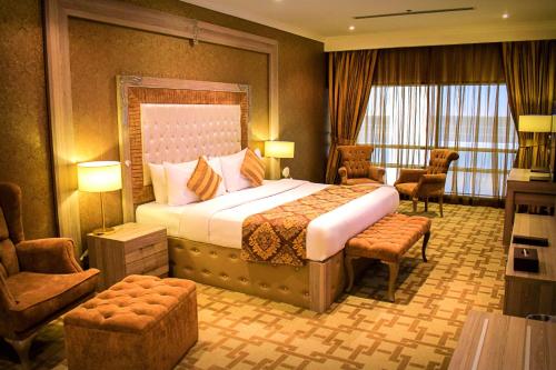 um quarto de hotel com uma cama grande e uma cadeira em Sapphire Plaza Hotel em Doha