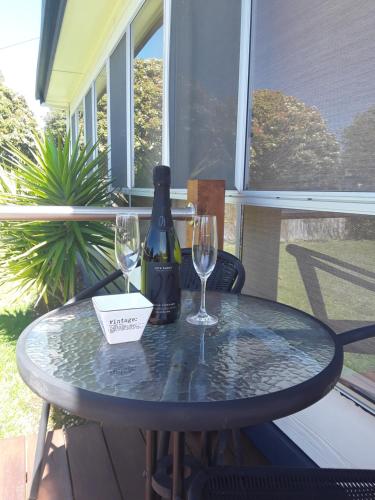 a table with a bottle of wine and two glasses at Bay Bell Cottage in Saint Leonards