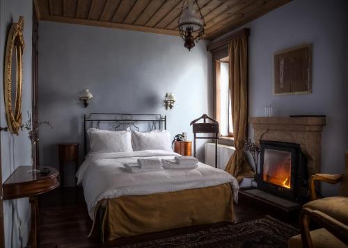 a bedroom with a bed and a fireplace at Nymfes Hotel in Nimfaíon