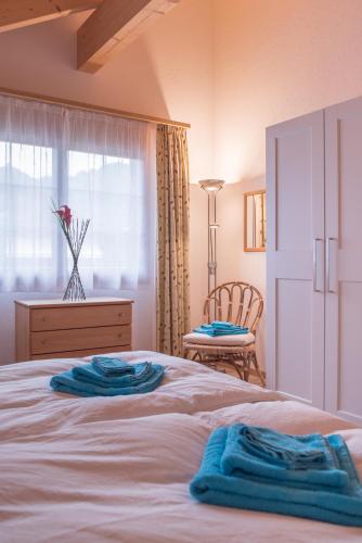 a bedroom with a bed with two blue towels on it at Apartment Lauberhorn, Luxury with best views in Lauterbrunnen