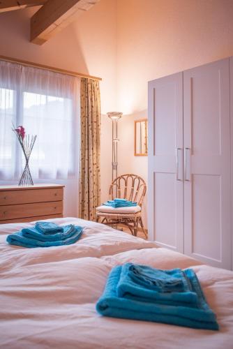 a bedroom with a bed with two blue towels on it at Apartment Lauberhorn, Luxury with best views in Lauterbrunnen