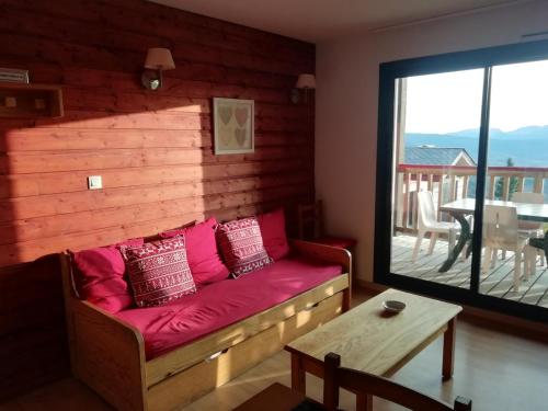 een woonkamer met een bank en een tafel bij Font-Romeu près des pistes - Appartement 2 pièces très lumineux avec terrasse et vue panoramique in Font Romeu Odeillo Via