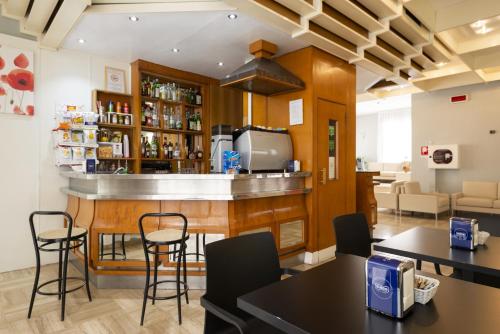 un bar en una habitación con mesas y sillas en Hotel Milena, en Rímini
