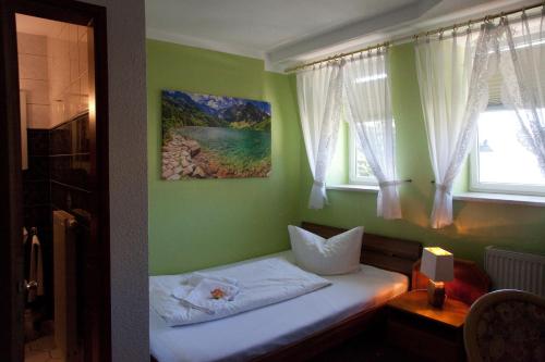 a small bed in a room with a window at Ratskeller Thum in Thum