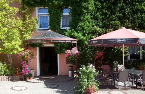 a patio with an umbrella and tables and chairs at Ratskeller Thum in Thum