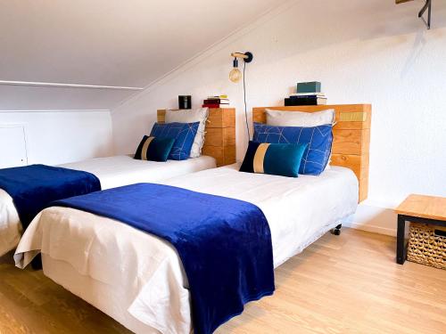 deux lits dans une chambre avec du bleu et du blanc dans l'établissement La Villa 103, à Lombez