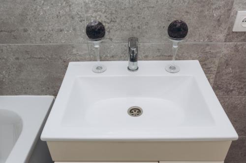 a white bathroom sink with two wine glasses on it at Apart-hotel I. Sirko New Building 3 floor in Sumy