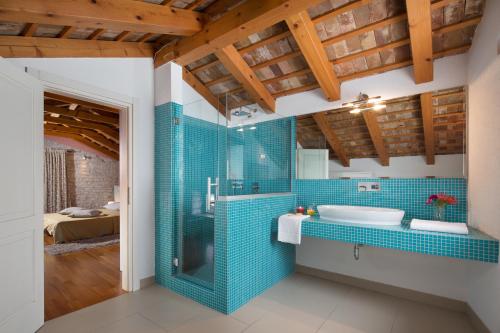 a bathroom with a tub and a sink with blue tiles at Art Villa Sis in Rovinj