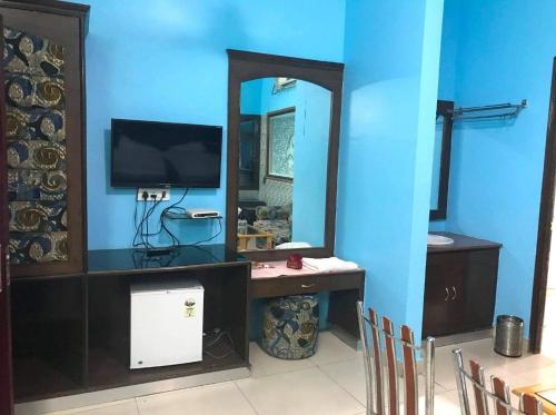 a bathroom with a mirror and a sink and a television at Gulshah Hotel in Jalandhar
