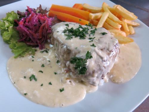 a plate of food with meat and dip and vegetables at Hotel Fontana in Novi Sad